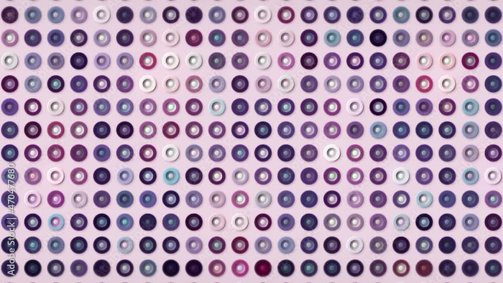 Poster Multicolored buttons shimmering isolated on a light pink background, seamless loop. Motion. Silhouettes of tiny rings in purple tones.