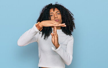 Young african american girl wearing casual clothes doing time out gesture with hands, frustrated...