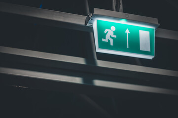 Glowing sign of direction to the exit. Equipping the premises with indicators of the movement of people to the emergency exits. Selective focus