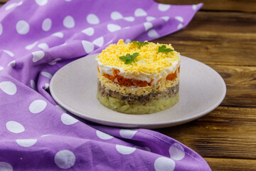 Traditional russian salad Mimosa on wooden table