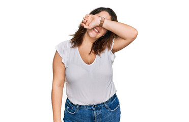 Young plus size woman wearing casual white t shirt covering eyes with arm smiling cheerful and funny. blind concept.