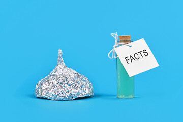 Concept for fighting conspiracy theories with facts with tinfoil hat and cure bottle with word...