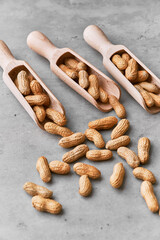 Image of wooden spoons with peanuts on a concrete surface