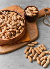 Image of wooden spoons with peanuts on a concrete surface