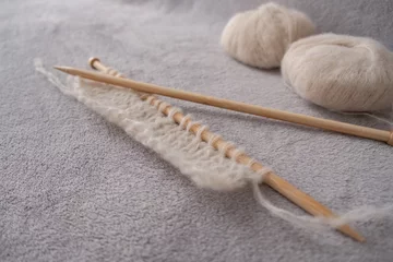 Foto auf Alu-Dibond Incomplete knitting project with soft light alpaca silk yarn and bamboo knitting needles © Paula