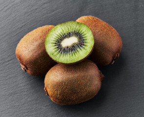  Bunch of kiwis and slice on a blackboard surface