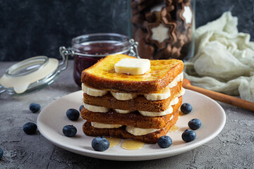 French toast with banana, blueberry, honey and strawberry jam. Delicious morning breakfast or brunch with toast and cookies