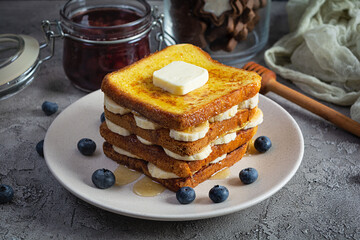 French toast with banana, blueberry, honey and strawberry jam. Delicious morning breakfast or brunch with toast and cookies