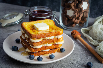 French toast with banana, blueberry, honey and strawberry jam. Delicious morning breakfast or brunch with toast and cookies