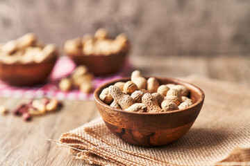  Bowls of peanuts with shell on a wooden surface