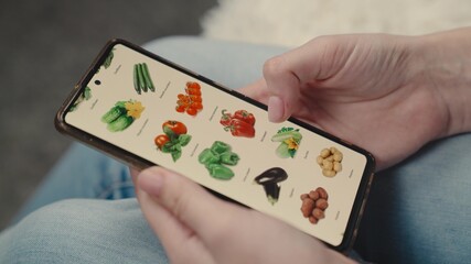 girl hand makes purchase vegetables smartphone, an online vegetable supermarket, an online store,...