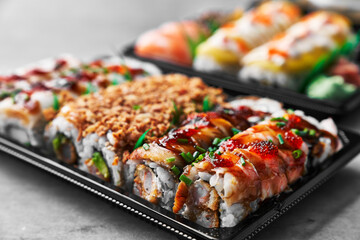  Delivery tray of uramaki sushi on a concrete surface