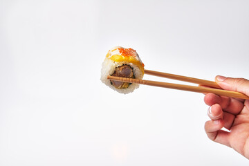  Chopsticks holding single shrimp uramaki sushi isolated on white background - Powered by Adobe