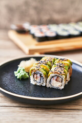  Plate of shrimp and cheese cream uramaki sushi on a wooden surface