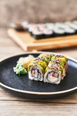 Fotobehang  Plate of shrimp and cheese cream uramaki sushi on a wooden surface © Krakenimages.com