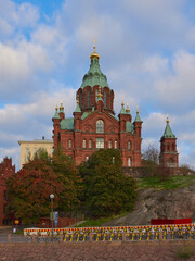 Fototapeta na wymiar Orthodox Uspensky Cathedral in Helsinki: katajanokka, autumn, red brick, old historic building, stone, blue beautiful sky.