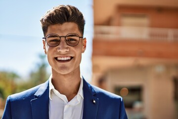 Obraz premium Young man smiling confident wearing suit and glasses at street