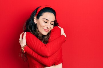 Young hispanic woman wearing casual clothes hugging oneself happy and positive, smiling confident. self love and self care