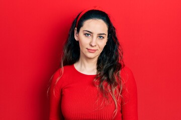 Young hispanic woman wearing casual clothes relaxed with serious expression on face. simple and...
