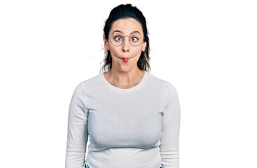 Young hispanic woman wearing casual clothes making fish face with lips, crazy and comical gesture....