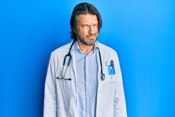 Middle age handsome man wearing doctor uniform and stethoscope skeptic and nervous, frowning upset because of problem. negative person.