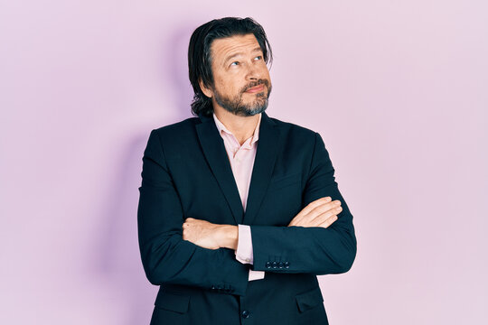 Middle age caucasian man wearing business clothes with arms crossed gesture smiling looking to the side and staring away thinking.