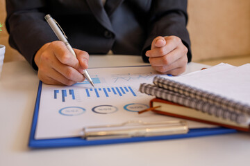Close up of hand,Financial Businesswomen analyze the graph of the company's performance to create profits and growth, Market research reports and income statistics, Financial and Accounting concept.