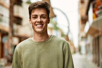 Obraz premium Young hispanic man smiling happy standing at the city.