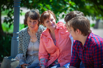 Happy family mother, sons and grandmother in the park