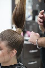 Work in a hairdressing salon. High tail. Measurement with fingers by hairdresser before start.