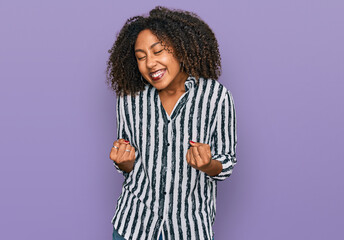 Young african american girl wearing casual clothes very happy and excited doing winner gesture with...