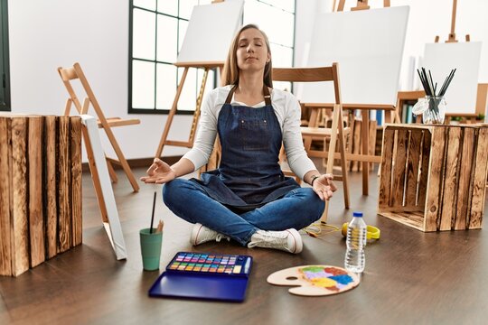 Young caucasian woman doing yoga exercise at art studio