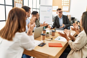 Obraz premium Group of business workers smiling and clapping to partner at the office.