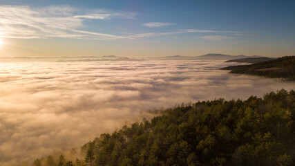 Italy November 2021: aerial view of mountains with fog below in autumn season at sunset