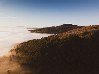 Italy November 2021: aerial view of mountains with fog below in autumn season at sunset