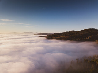Italy November 2021: aerial view of mountains with fog below in autumn season at sunset