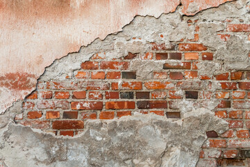 Old brick wall, cement and plaster peel off . Background, texture. Closeup.