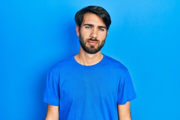 Obraz premium Young hispanic man wearing casual clothes looking sleepy and tired, exhausted for fatigue and hangover, lazy eyes in the morning.