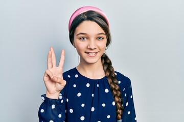Obraz na płótnie Canvas Young brunette girl wearing elegant look showing and pointing up with fingers number three while smiling confident and happy.