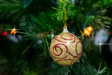 Colorful shining balls, garland, ribbons  are hanging  on branches of christmas tree. Decorated christmas tree as party background or celebration card.