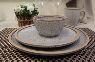 Gray pottery is on the dining table.