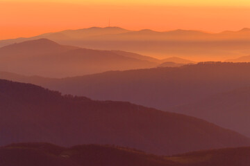 Abstract orange sunset over the evening mountains
