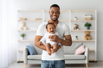 Parent And Baby. Happy Young Black Father With Infant Child On Hands