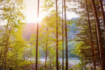 Early morning in the mountains - sunrise over the mountain by the river in the taiga. Siberia, Russia.