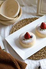 Delicious Japanese fluffy souffle pancakes on white cafe table.