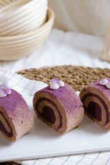 Delicious Swiss Roll Cake with sweet purple potato filling on white cafe table.