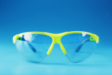 Technological protective green glasses isolated on a blue background.