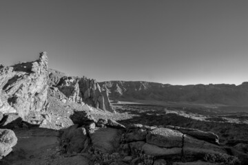 Black and white scenery of a barren volcanic landscape with sharp rocks and desert. Panorama of the...