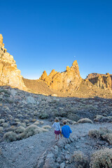 Family trip in the desert. Dad and young daughter in adventures hiking in peaceful sunset in Tenerife Natural park. A girl and a man in a natural path.