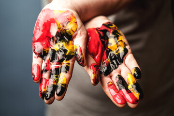 Womens palms painted with multi-colored acrylic paints close-up